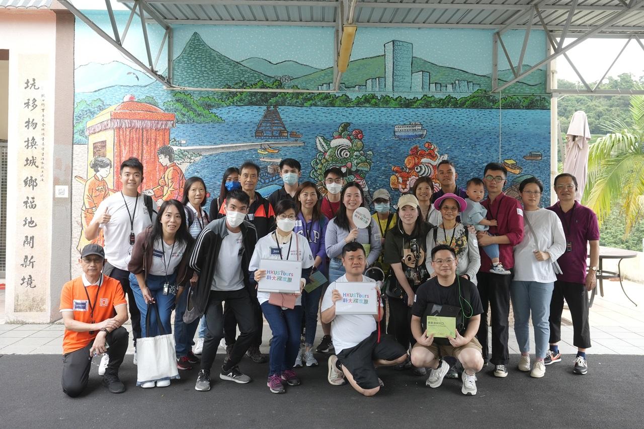 導賞團在坑口村一幅客家傳統及舞麒麟文化壁畫前留影。