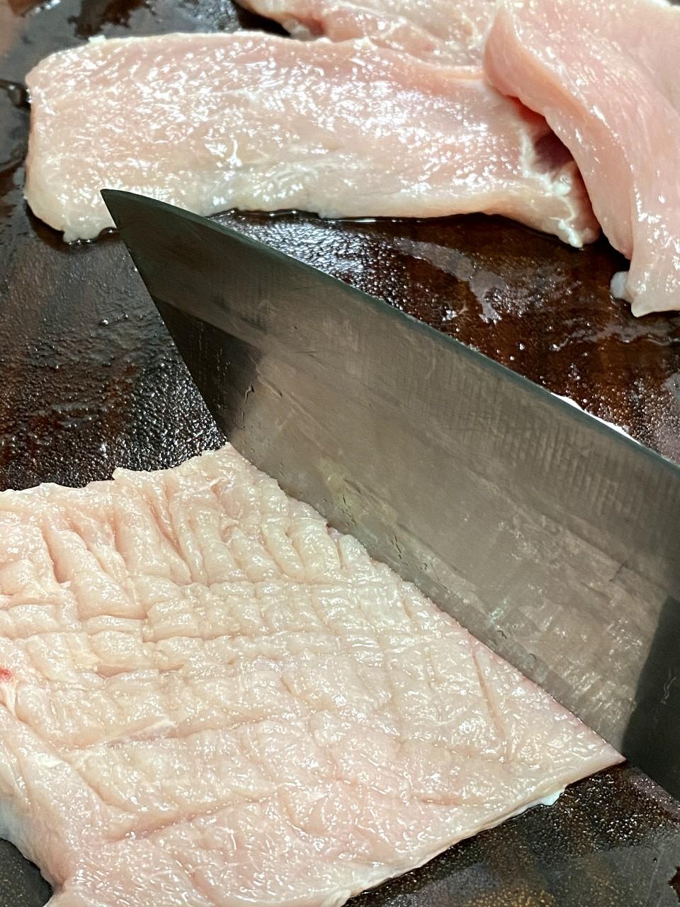 椒鹽豬扒食譜│步驟1 豬扒用刀背打十字拍鬆,切小塊。紅椒和葱切粒,蒜頭切碎備用。