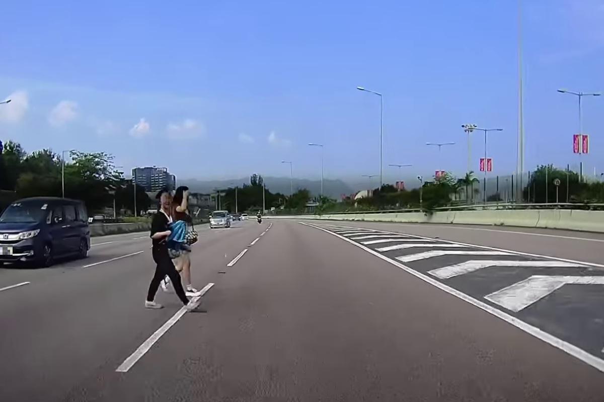 一段流傳的車Cam片顯示,兩名女子十分淡定地在吐露港公路過馬路。(網上影片截圖)