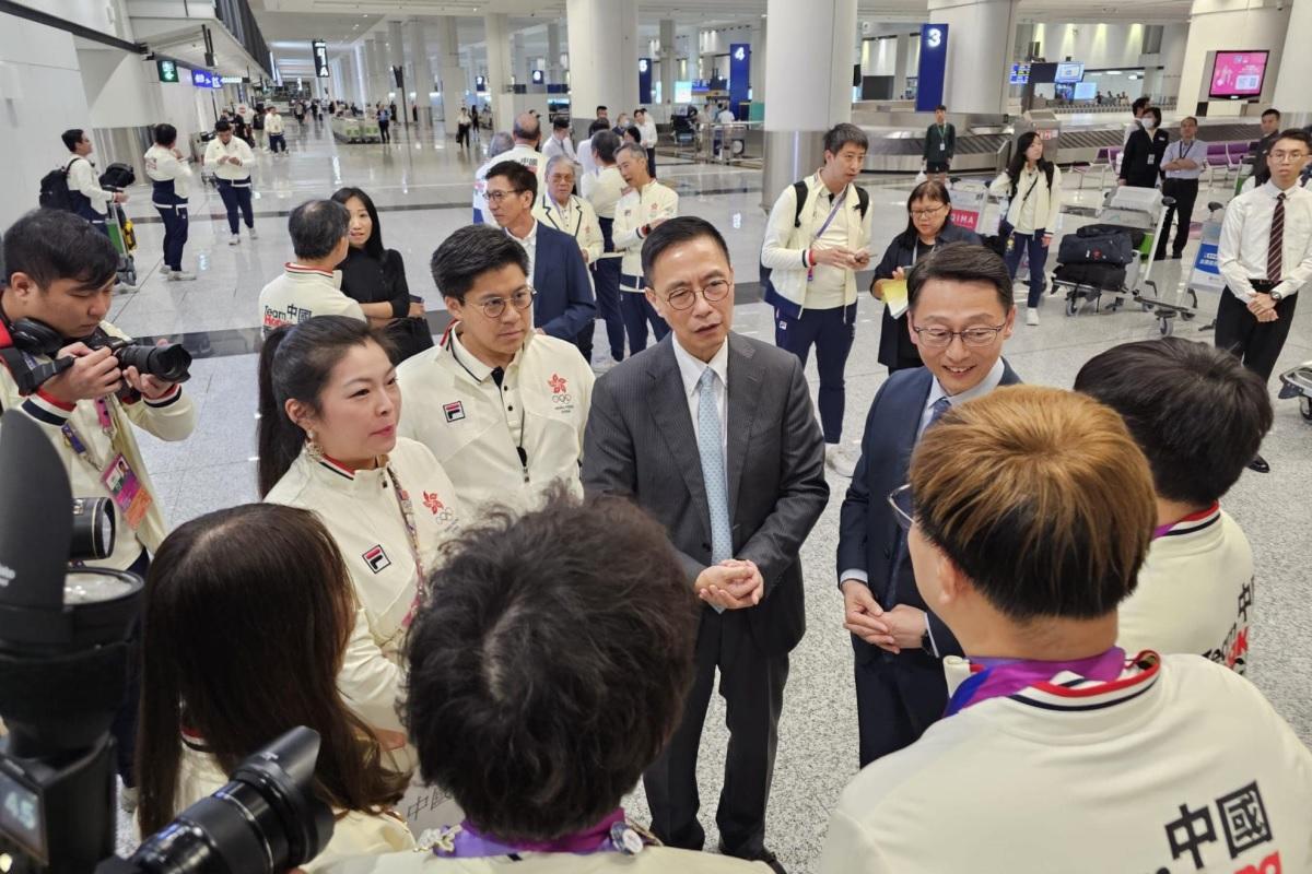 (面向鏡頭者右起)劉明光、楊潤雄和霍啟剛與港隊運動員在機場禁區交談。(楊潤雄FB)