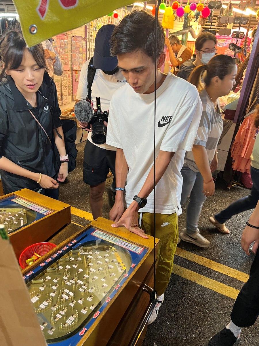 日本跑手大迫傑到訪台灣中壢夜市,玩了兩個遊戲獲得獎品(EKIDEN SPORTS 提供)