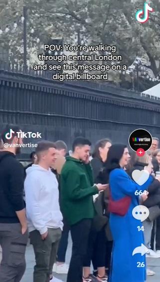 路人停下來看廣告板。(互聯網)