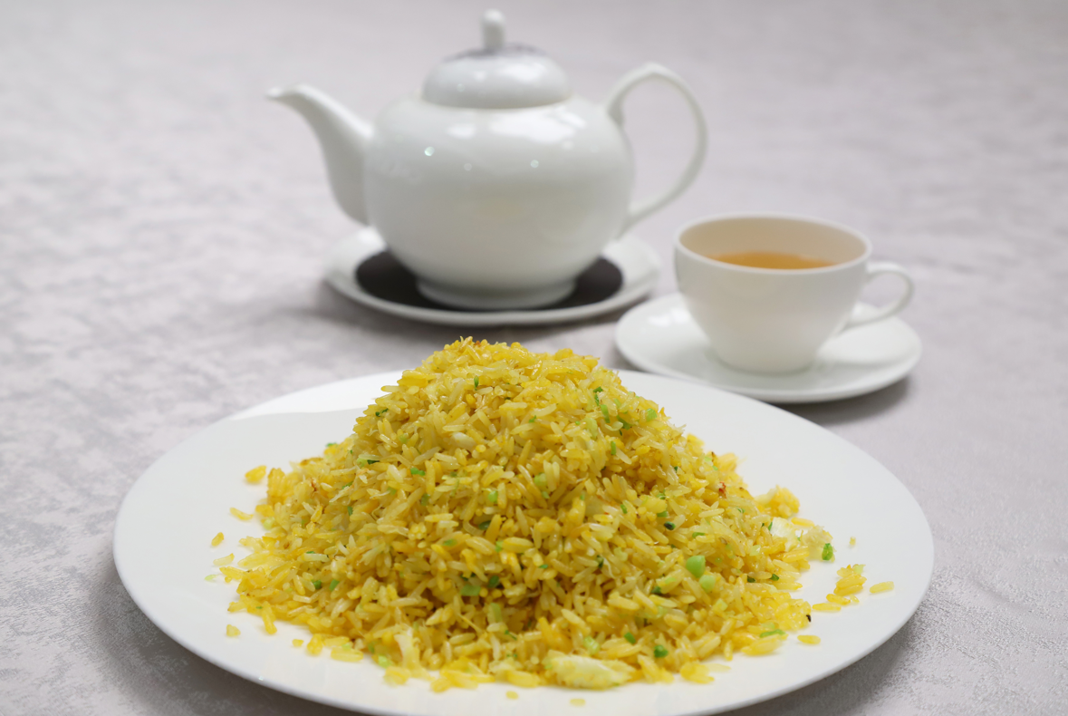 阿翁炒飯以蟹黃、蛋黃、蟹肉為主要材料,並以金華火腿汁調味,不單色香味俱全,更有金鑲銀的好意頭。(攝:羅錦鴻)