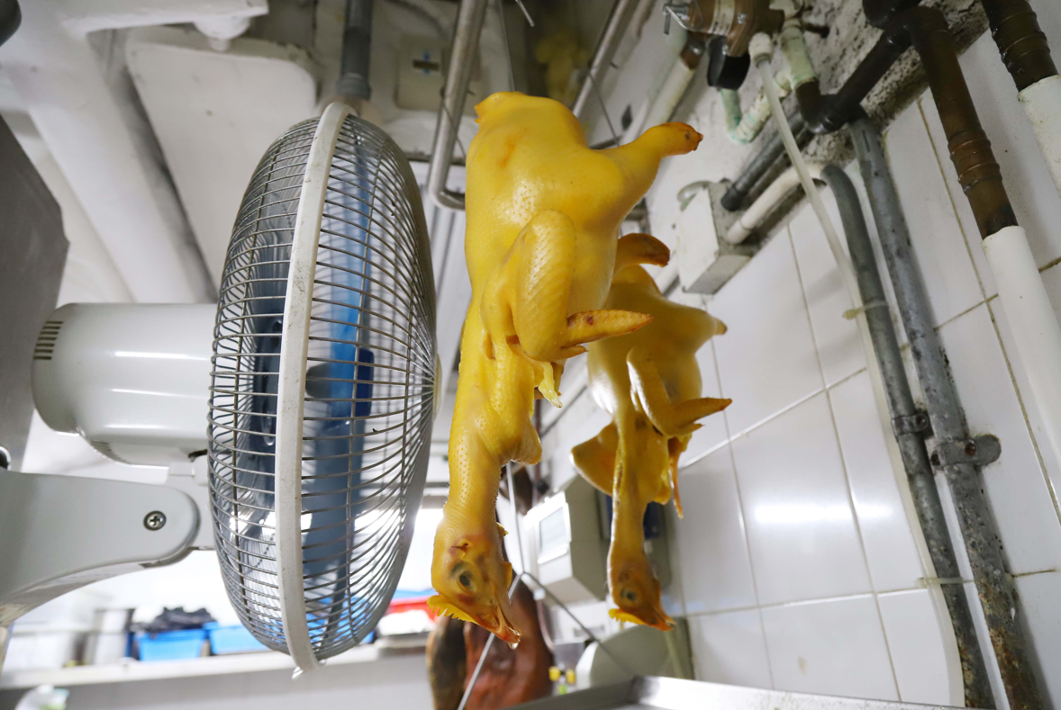 炸子雞的工序繁複,醃好後要風乾4小時再炸,再風乾後才用滾油一遍遍地淋熟它。(攝:羅錦鴻)