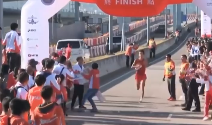 內地跑手謝冬生衝線時,衝線帶突被工作人員收走。(直播畫面)
