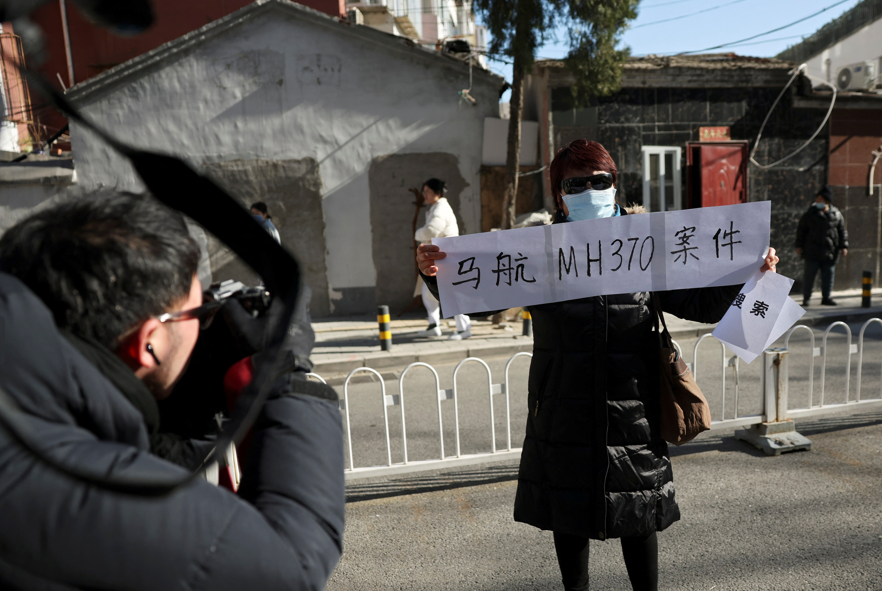 公安早上在法院外拉起封鎖線,多架警車在場戒備,有家屬展示標語,要求案件公開審理。(路透社)
