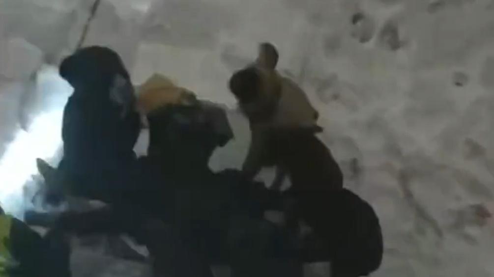 救援人員持手提電筒在廢墟中搜救,並以擔架將傷者抬出。(微博)
