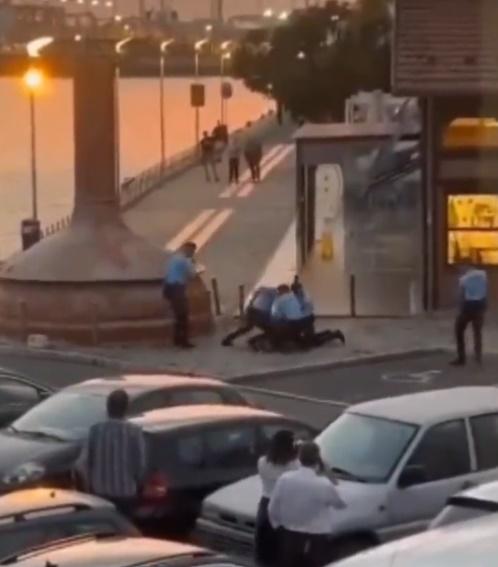 一名男子趴在地上,5名武裝警員擎槍指嚇並包圍他,隨後上前將他上鎖帶返警署。(X)