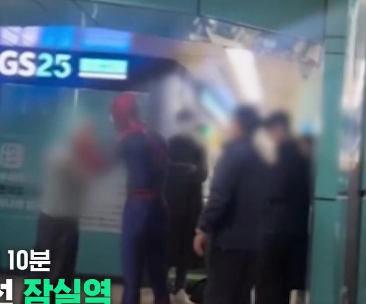 「蜘蛛俠」握著流浪漢的拳頭,還「拉」著對方的手,看去就如在跳舞,令現場氣氛變得奇幻。(YouTube)