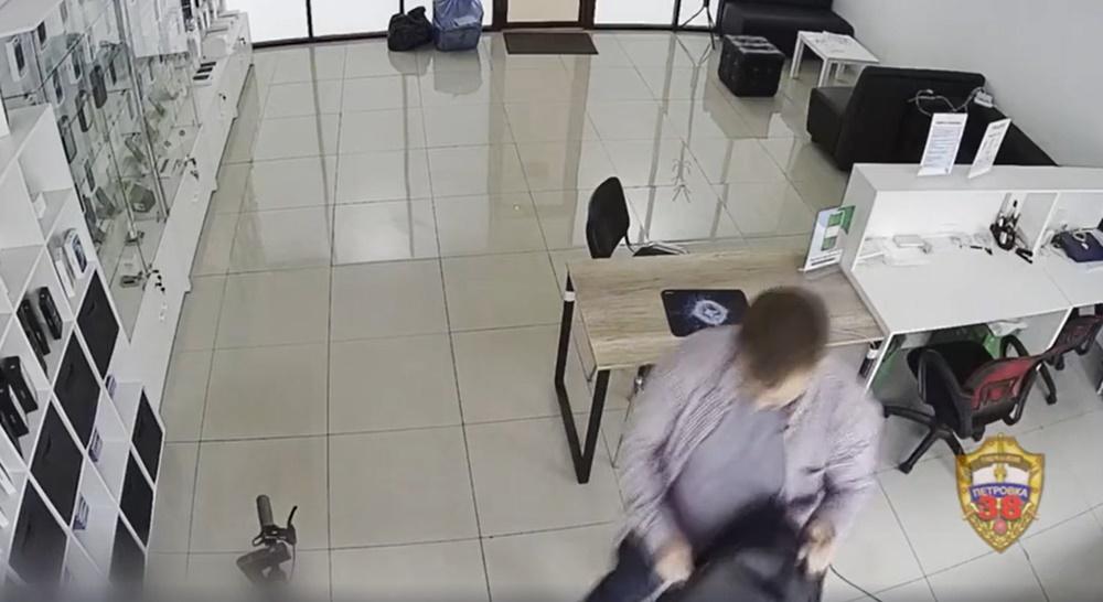 男子在電子產品店裡拿出一個行李箱和多個袋子中裝滿數十個全新未拆封iPhone。(網上截圖)