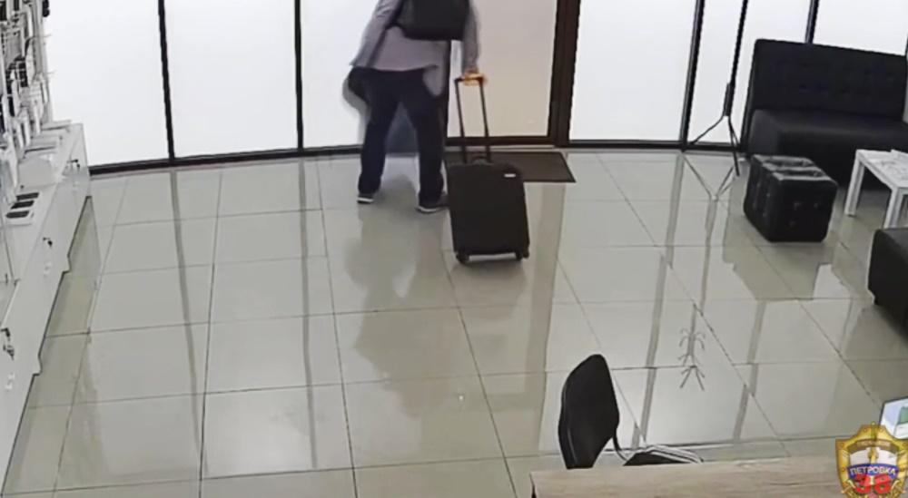 男子在電子產品店裡拿出一個行李箱和多個袋子中裝滿數十個全新未拆封iPhone。(網上截圖)