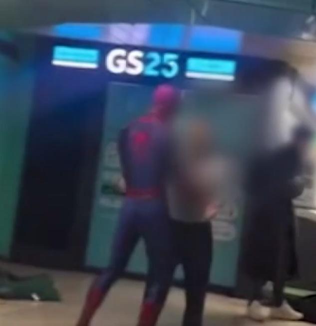 「蜘蛛俠」握著流浪漢的拳頭,還「拉」著對方的手,看去就如在跳舞,令現場氣氛變得奇幻。(YouTube)