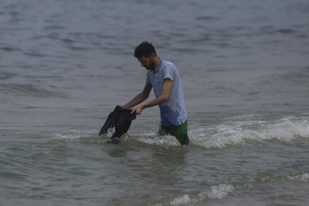 因缺水,加沙民眾在海邊洗衣服。(美聯社)