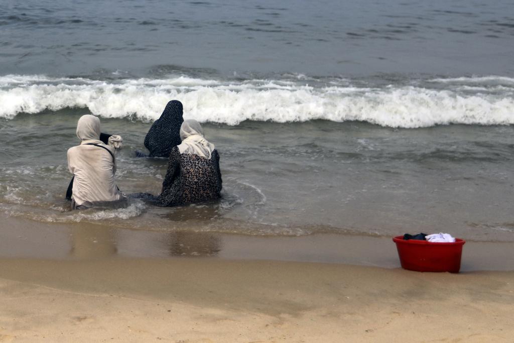 因缺水,加沙民眾在海邊洗衣服。(美聯社)