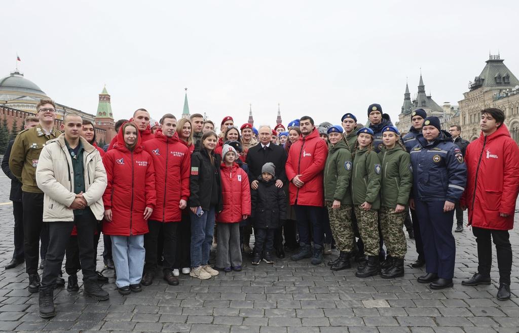 普京上周六出席莫斯科紅場一個獻花儀式,與民眾合照。(美聯社)