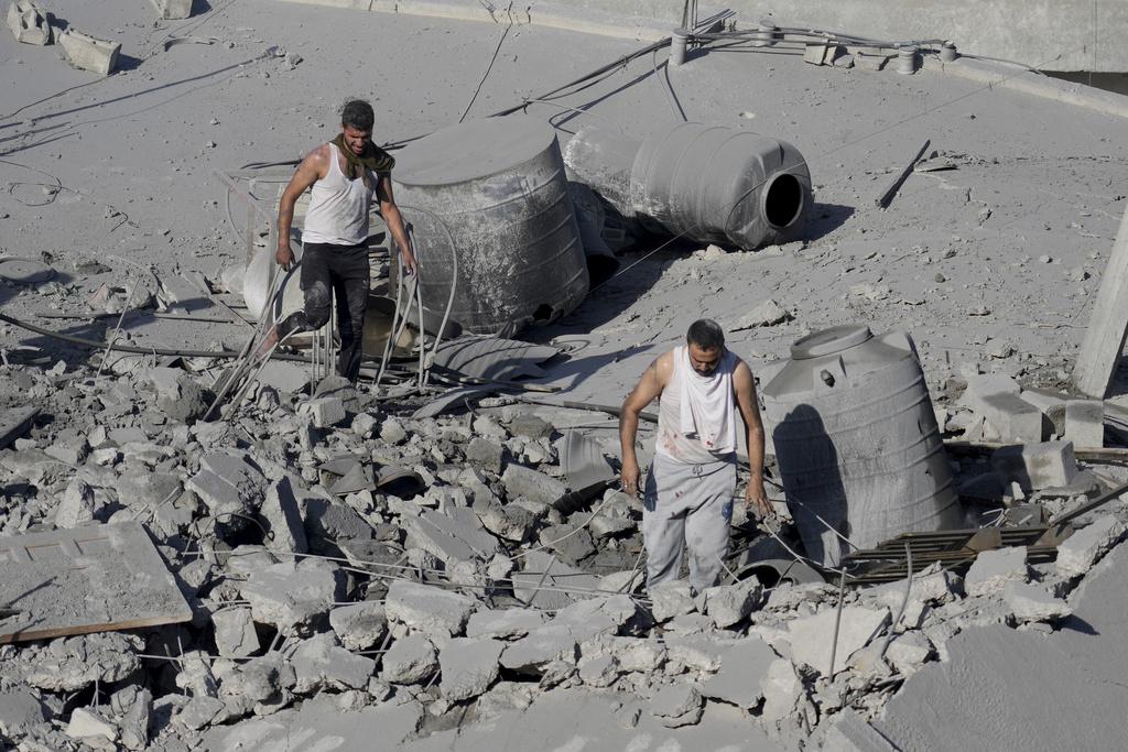 加沙Nusseirat難民營周六受以軍空襲,民眾搜索受困瓦礫的人。(美聯社)