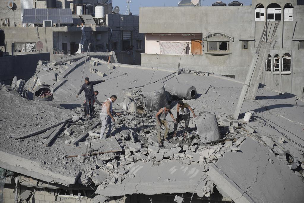 加沙Nusseirat難民營周六受以軍空襲,民眾搜索受困瓦礫的人。(美聯社)