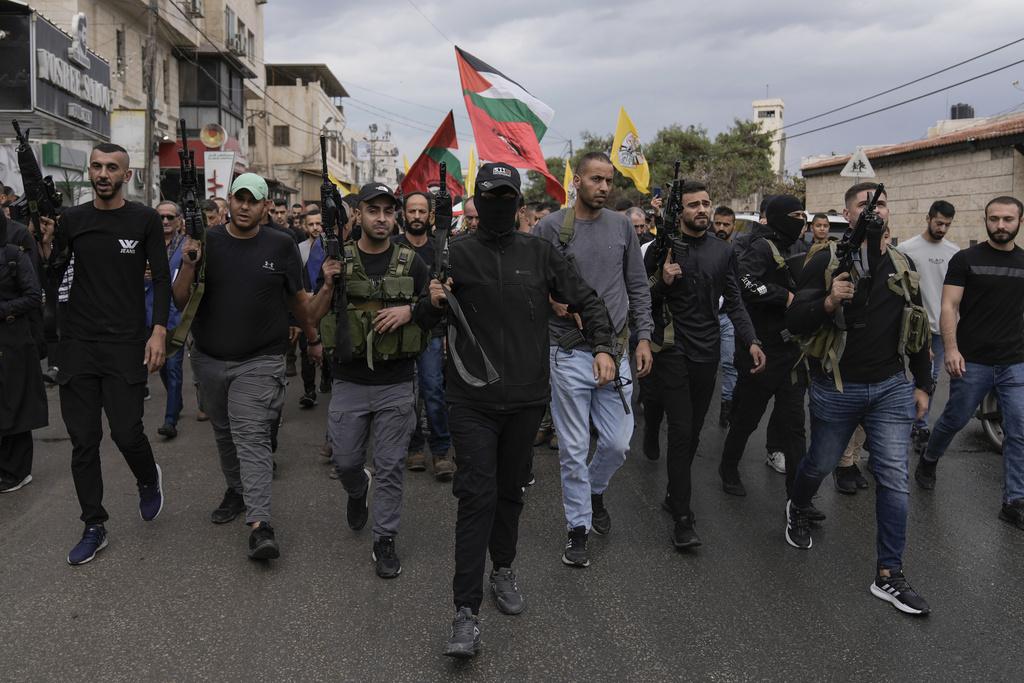 以巴衝突|西岸一個巴人難民營近日遭受以軍攻擊,巴人武裝分子為死者舉殯。(美聯社)