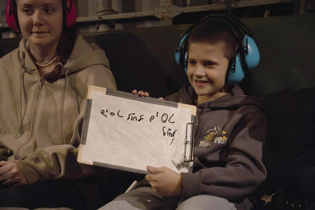 9歲男童與姊姊獲釋後乘直升機返回以色列,在機上以希伯來文寫著「在機上」。(美聯社)