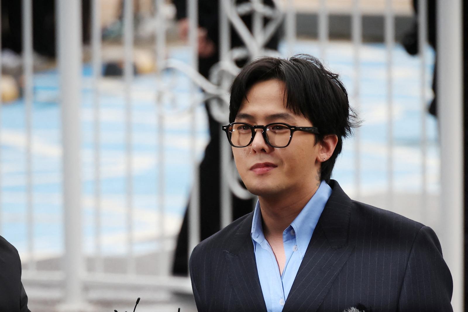 G-DRAGON涉毒現身警局助查150警恭候,他一度露出笑容。(路透社)