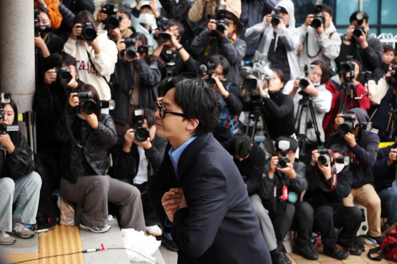 G-DRAGON涉毒現身警局助查150警恭候,近百記者圍影GD進入警局。(路透社)