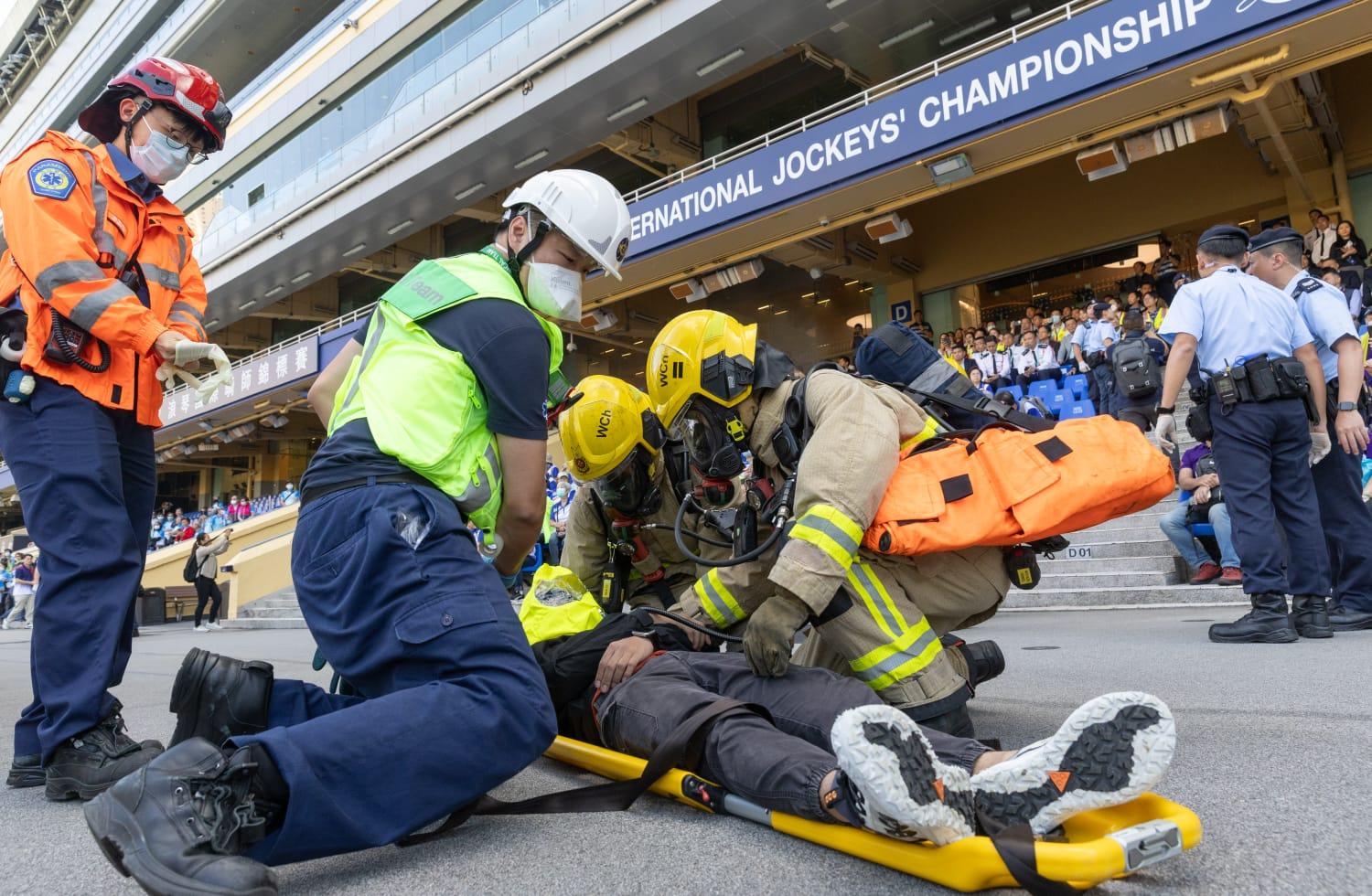跨部門重大事故聯合演習模擬在跑馬地馬場公眾投注大堂發生大火引致多人受傷,人員展開救援行動,疏散在場人士及為傷者急救等。(蘇文傑攝)