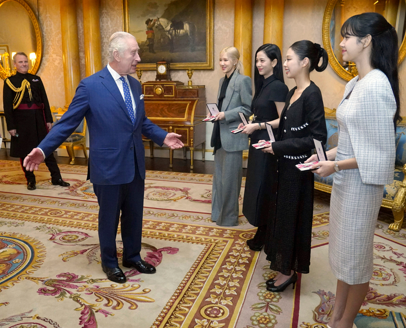 南韓女子組合BLACKPINK四位成員,她們獲得英王查理斯三世頒授員佐勳章,表揚她們在倡議重視氣候議題方面的工作。(美聯社)