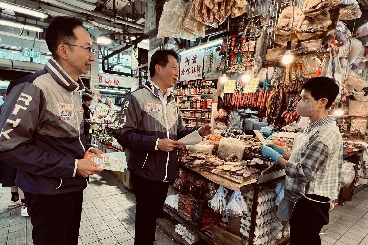 張國財(中)向屯門商戶派發區議會選舉宣傳單張。(港台提供)