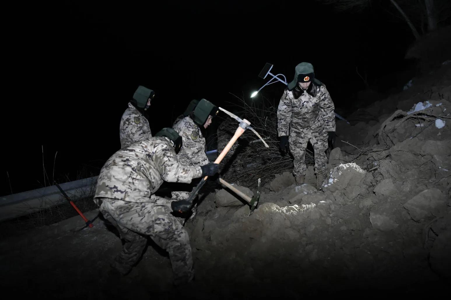 19日晚間救難人員持續以工具鑿開崩塌土石進行救援。(圖/新華社)