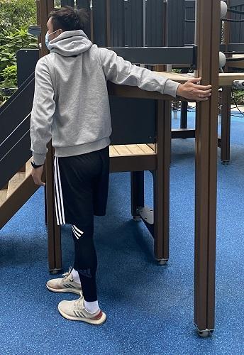 右手伸直並向後提。