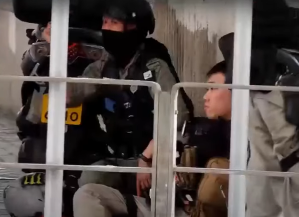 唐英傑在2020年7月1日被指駕駛涉及港獨旗幟電單車在灣仔撞向警方防線,造成三名警員受傷,2021年7月被裁定煽動分裂國家及恐怖活動兩罪成立,被判囚共9年。(電視截圖)