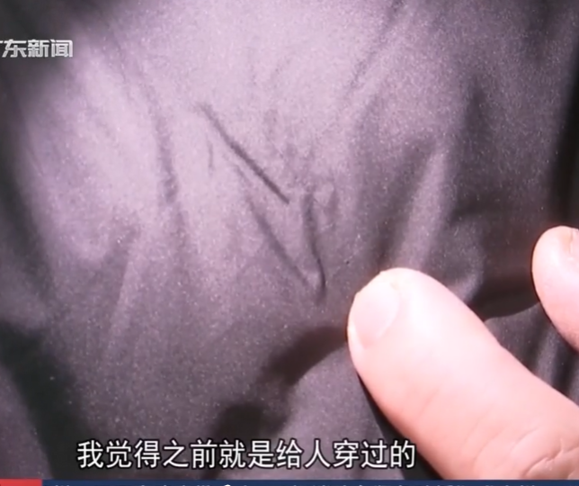 佛山一名男子花費718元人民幣網購一件黑色羽絨服,收到貨後竟在口袋發現白色喪葬胸花,衣服胸口處還疑有佩戴過的痕跡,與店家溝通協商後,對方同意退款退貨並賠償300元(約335港元)。(電視截圖)