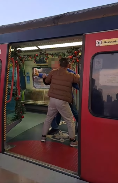 一名身穿藍色羽絨外套的中年男子疑不滿男童玩門,以粗口責罵對方,多名在旁市民調停