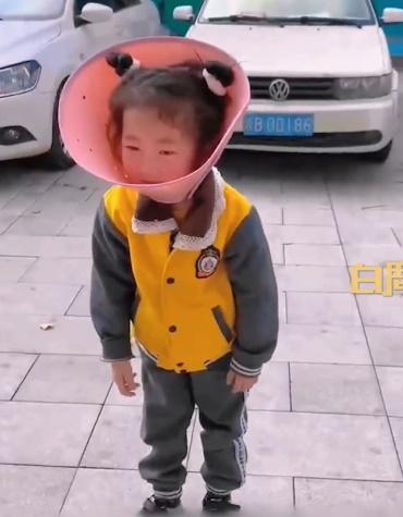 戴著「燈罩」的女童相當不滿。(微博)