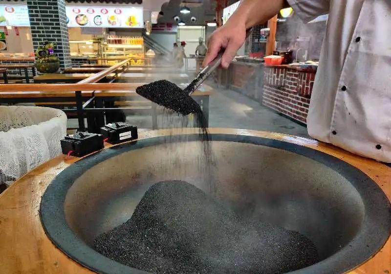 炒製黑芝麻,是製作寧波湯圓中的重要環節之一,優質芝麻經過浸泡、瀝乾、晾曬等步驟,被放入鍋中翻炒,10多分鐘之後,芝麻開始「劈啪作響」,這時可以關火,而翻炒仍在繼續,一直到芝麻在鍋中「安靜」下來,才算成功。(圖片來源:寧波人物@微博)