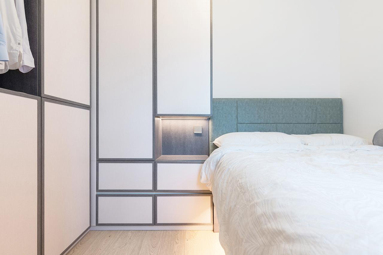 主人房淺色木櫃配襯灰色框邊,床頭以冷色系藍色作配搭,展現出型格的格調