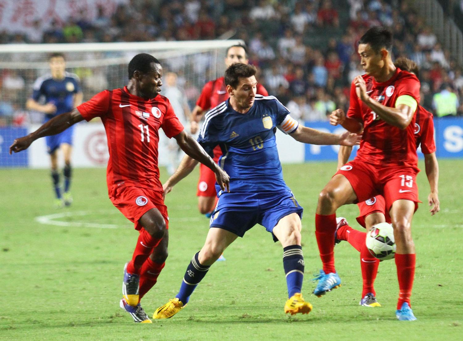 美斯2014年帶領阿根廷以7︰0大勝香港足球隊,圖為球王被陳偉豪及安基斯夾擊。(資料圖片)