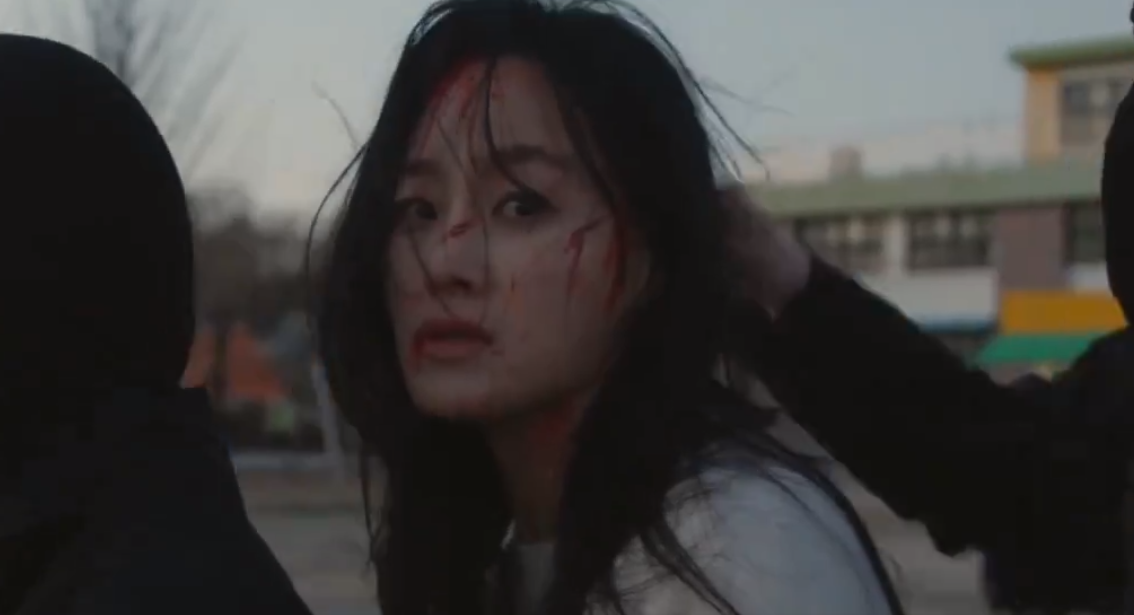 ,頭部渾身是血的母親被武裝分子綁架。她四處張望着尋找孩子,但只看到地上留下孩子的一雙紅手套。