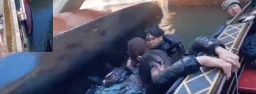 中國遊客跌落水後,抓緊船邊待救。(互聯網)