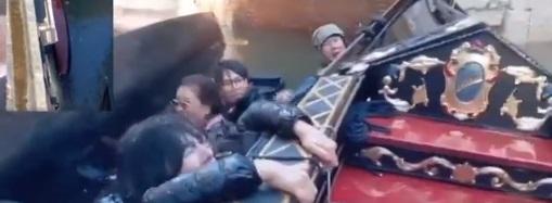 中國遊客跌落水後,抓緊船邊,相當狼狽。(互聯網)