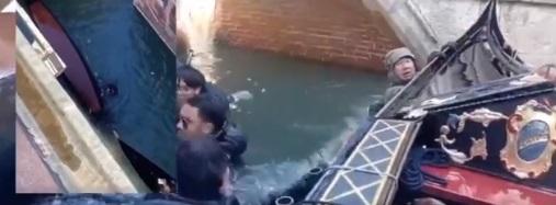 中國遊客跌落水後,抓緊船邊待救。(互聯網)