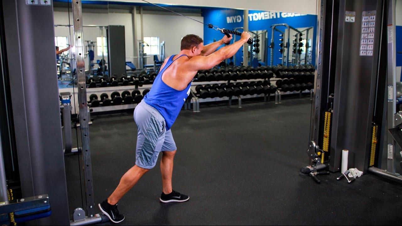 過頭三頭屈伸,雙手捉住手把,轉身背對器械並將手把轉向頭後,上臂上舉手肘屈曲,腳可前後站立穩定身體,腹部收緊