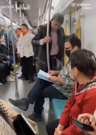 這名戴黑色面罩的外籍男當時坐在北京地鐵4號線車廂座位上安靜看書。此時一名疑似有酒氣的中年男子莫名靠近頻繁挑釁