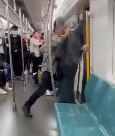 地鐵到站後,外籍男把他推出車廂,及後坐回座位。