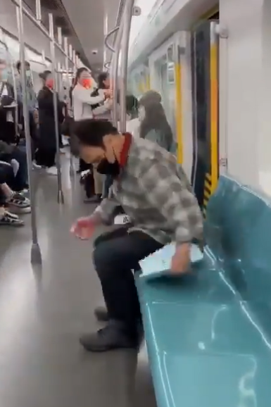 地鐵到站後,外籍男把他推出車廂,及後坐回座位。