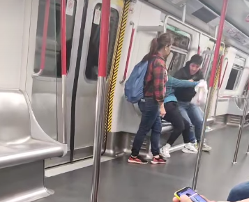 社交平台今日(22日)網上流傳一段影片,可見一名非常憤怒的女子於港鐵車廂內不停拳毆同行黑衫人士,其間以非英文外語大罵對方。(香港突發事故報料區及討論區)