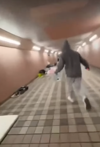 網上流傳影片可見,數名年輕人在跑馬地一條行人隧道向露宿者淋潑清水及可樂後,立即跑走逃去。(網上影片截圖)