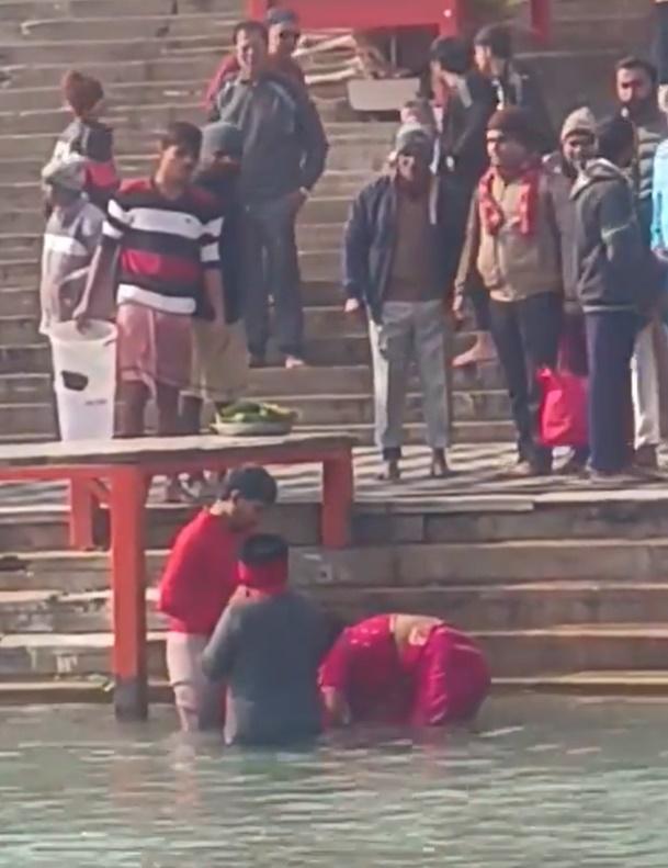 網上影片顯示,男童的父母一邊唸誦著經文,一邊看著兒子被他的阿姨淹沒在恆河水裡。(X)