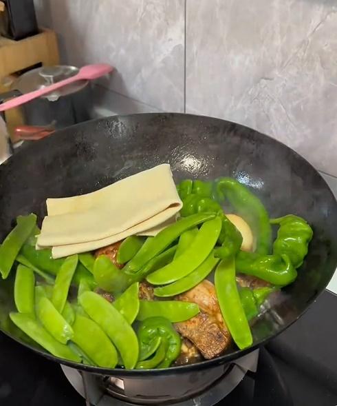 片中主人翁在一個大鐵鑊裡放水,再將各式各樣的食材放入。(微博)