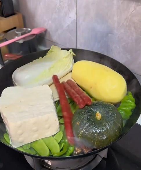 片中主人翁在一個大鐵鑊裡放水,再將各式各樣的食材放入。(微博)